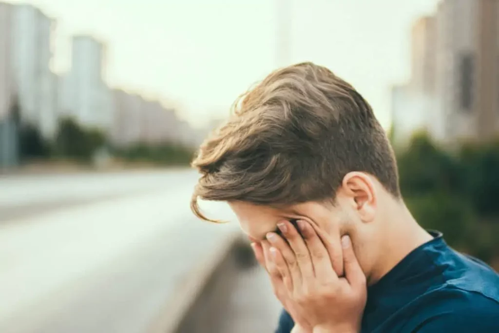 a man covering his face